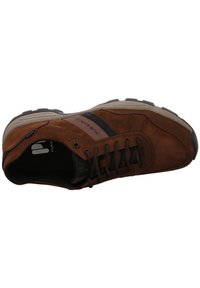 Braune Wildleder-Sneaker mit einem schwarzen Stoffstreifen, schnürbarem Design, gepolstertem Schaft und einer strukturierten Gummi-Sohle für besseren Halt.