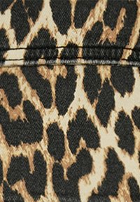 Tessuto con stampa leopardata con uno sfondo beige e distintive macchie nere. Tela strutturata con linee di cucitura dettagliate.