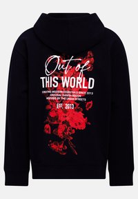 Felpa nera con cappuccio caratterizzata da un grande design floreale rosso con testo bianco che recita "Fuori da QUESTO MONDO" e ulteriori dettagli di branding sottostanti.
