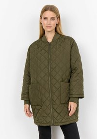 Gequilte olijfgroene jas met een rits, ribgebreide manchetten en twee voorzakken. Voorzien van een ronde halslijn en een lose pasvorm.
