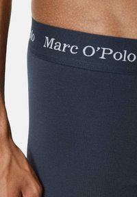 Boxer briefs in cotone navy con un morbido elastico in vita riportante la scritta "Marc O'Polo" in lettere bianche. Texture liscia, design aderente.