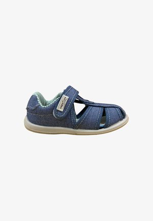 Sandalía azul para niño pequeño con puntera cerrada, tira de velcro, forro interior acolchado y suela beige flexible, aislada sobre fondo blanco.