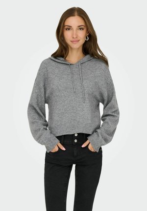 Sudadera corta gris de punto con cordón, puños y dobladillo acanalados; combinada con jeans negros con bolsillos y botones plateados.