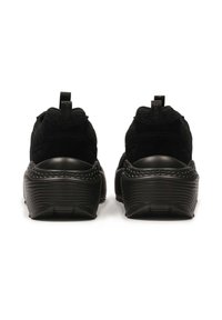 Črne športne čevlje z teksturirano mrežasto zgornjšo plastjo in gumijastim podplatom. Imajo zanko na peti in valovito, nazubljeno zasnovo.