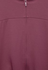 Reißverschluss-Sweatshirt in einem reichen Burgunderrot, mit glatter Textur und Nahtdetails entlang des Rückens und der Schulterpartien.