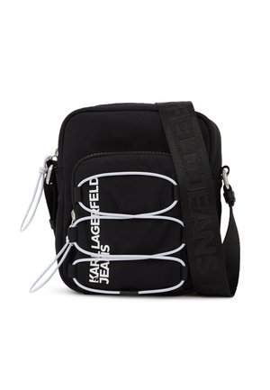 Sort skuldertaske med hvide elastiske løkker, lynlåstræk og hvid "KARL LAGERFELD JEANS" tekst på frontlommen.