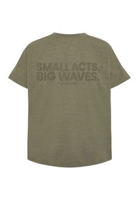 Olivza zaļš lielgabarīta T-krekls, īsām piedurknēm, ar lielu tekstu grafiku uz aizmugures, kas lasa "MAZIE DARBI, LIELIE VIĻŅI." Mīksta tekstūra.