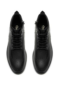 Černé kožené brogue boty s texturovaným povrchem, pointed toe a dekorativní perforací, s šněrovacím designem a bočním zipem.