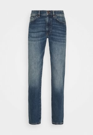 Jeans blu slavato a gamba dritta con tasche anteriori, passanti per cintura e chiusura con bottone, mostrati su sfondo bianco.