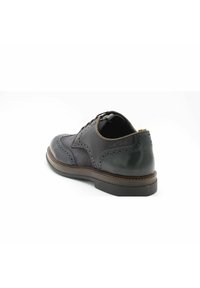 Chaussure habillée pour homme en cuir brun foncé avec une finition lisse, design à bouts carrés et détails en brogue. Dotée d'un bout rond et d'un talon bas empilé.