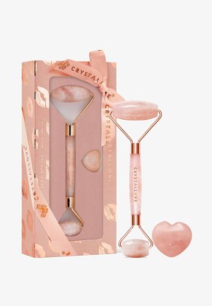 Zestaw do masażu z różowego kwarcu z różdżką w kształcie serca. Zawiera różowy kamień z akcentami ze złotego metalu. Zapakowane w wzorzyste pudełko.