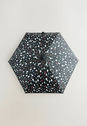 Svart paraply med ett mönster av färgglada droppar i rött, blått och vitt. Tygkupolen har åtta paneler och en slät yta.