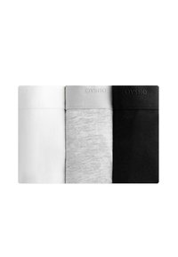 Tre par strumpor i vitt, ljusgrått och svart. Varje strumpa har en mjuk textur med en ribbad mudd och varumärkesnamnet "OYSHO" på banden.