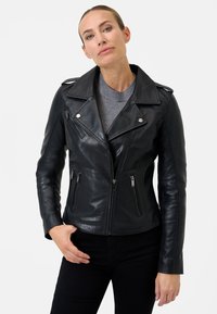 Giubbotto da motociclista in pelle nera con colletto a farfalla, chiusura con zip e due tasche laterali con zip. Texture liscia e design aderente.