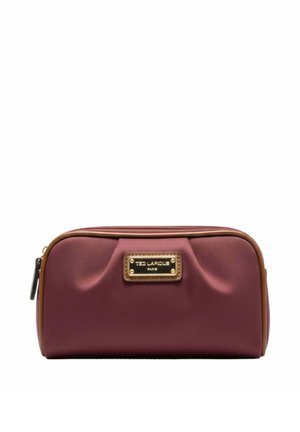 Trousse de toilette rectangulaire bordeaux avec garniture marron, plis avant, plaque logo dorée et fermeture éclair sur fond blanc.