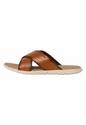 Sandales en cuir marron avec des brides croisées, semelle en caoutchouc beige, semelle intérieure texturée et logo discret sur la bride supérieure.
