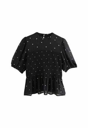 Blusa nera con maniche a palloncino, dotata di un corpino arricciato e pois bianchi, rifinita con un orlo a balza e chiusura a occhiello sul retro.