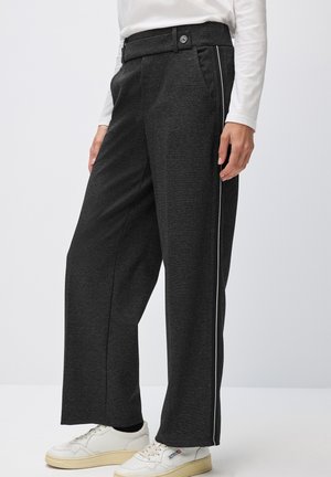 Un pantalon large en tissu gris foncé présente une texture lisse, une taille ceinturée avec une fermeture à bouton et des rayures latérales blanches contrastantes.