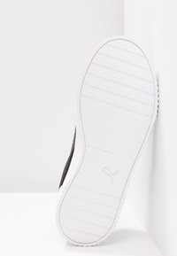Black athletic shoe with a textured upper, featuring a white rubber sole with ridges and a logo embossed on the side.