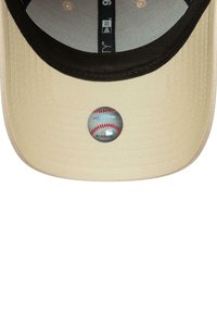 Innenansicht einer beigen Baseballmütze mit schwarzem Rand und offiziellem holografischen Aufkleber der Major League Baseball auf dem gebogenen Schirm.