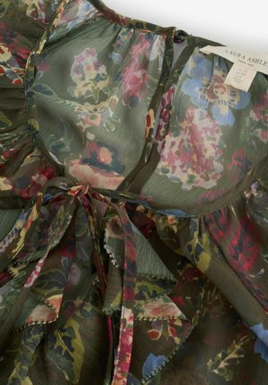 Bluse aus floraler Chiffon mit grünem Grundton, mehrfarbigen Blumenmustern, gerafften Kanten und einer Schnürung am Ausschnitt.