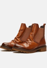 Botas de cuero marrón hasta el tobillo con paneles laterales elásticos, parte superior texturizada y suela resistente. Presentan un acabado suave y un tacón bajo apilado.
