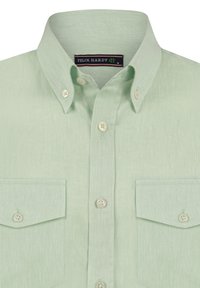 Chemise boutonnée vert clair avec un col, deux poches poitrine et des boutons blancs. Le tissu a une finition texturée et une coupe décontractée.