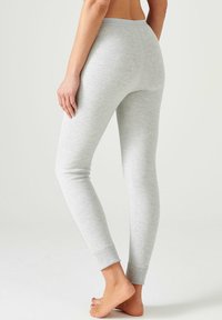Leggings grigi in morbido e elastico tessuto. Design aderente con vita stretta, gambe affusolate e polsini a costine alle caviglie.