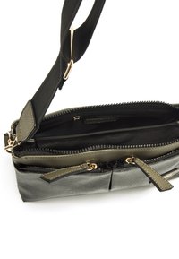 Grau-schwarze Tasche aus strukturiertem synthetischem Material mit Reißverschluss, verstellbarem Tragegurt und mehreren Fächern zur Organisation.
