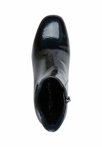 Bottine noire en vernis avec un design élégant, bout arrondi, fermeture éclair sur le côté et une finition lisse et brillante. À l'intérieur, on peut voir le nom de la marque "Tamaris."
