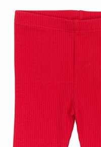 A piros bordázott leggings anyaga texturált, rugalmas derékpántja pedig a kényelmet szolgálja. A dizájn sima megjelenést kölcsönöz, köszönhetően a varrás nélküli kivitelezésnek.