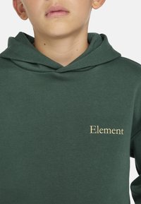Grüne Kapuzenjacke mit weicher Textur, versehen mit einem goldenen "Element"-Logo auf der linken Seite. Mit Kapuze und geripptem Kragen.