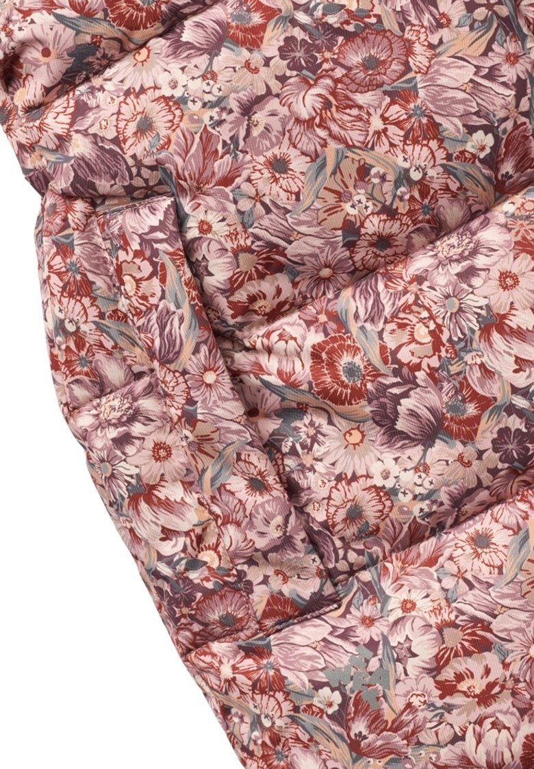 Stoff mit floralen Mustern in gedämpften Tönen von Pink, Rot und Blau. Texturierte Oberfläche mit einem weichen, gesteppten Aussehen und lebhaften Blumenmotiven.