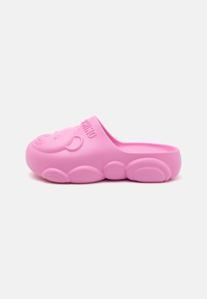 Zueco de goma rosa con punta redondeada, que presenta un diseño de cara de oso en relieve en la parte superior y una suela texturizada con acentos en forma de burbujas.