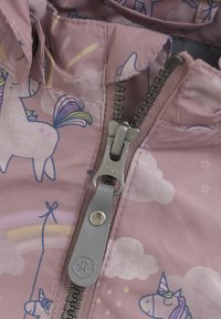 Tissu léger de veste rose avec des motifs de licornes et de nuages. Fermeture éclair centrée avec une tirette en argent et des accents en gris.