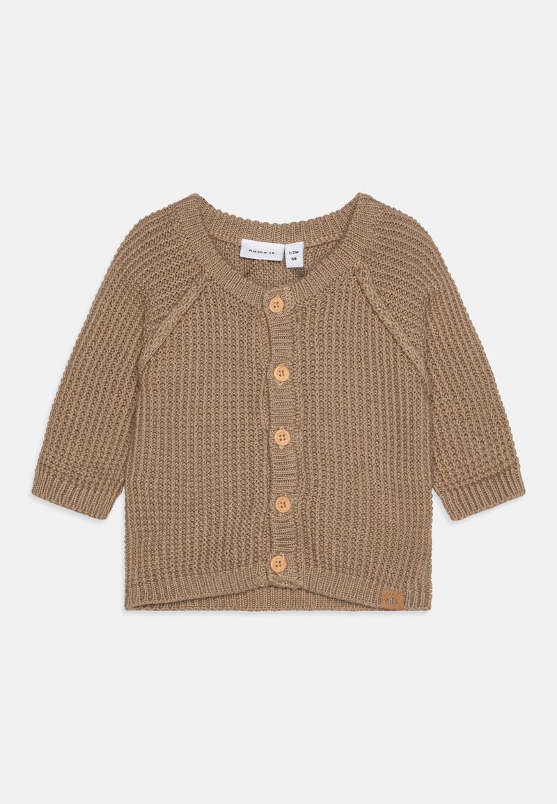 Adīta džemperis gaiši brūnā krāsā ar garām piedurknēm, apaļu kakla izgriezumu un koka pogām gar fronti; ar teksturētu ribota raksta dizainu.