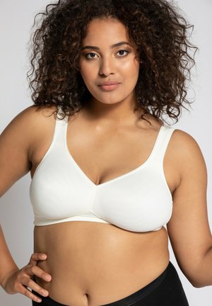 Witte, naadloze bralette met een v-hals ontwerp, brede bandjes en een zachte textuur. Opvallend door de comfortabele pasvorm en minimalistische stijl.