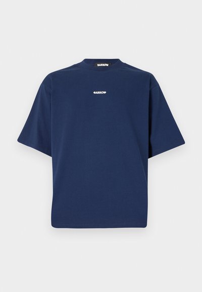 Laivansinis puuvillapaita, jossa on rento istuvuus, lyhyet hihat ja pyöreä kaula-aukko. Rinnassa on valkoinen logo painettuna.