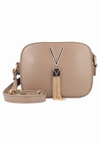 Beżowa torebka ze skóry o fakturze z ozdobnym złotym łańcuszkiem z frędzlami oraz wyraźnym akcentem w kształcie litery V. Dołączony regulowany pasek.