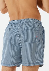 Marineblaue und weiße gestreifte Badehosen aus leichtem Material, mit einem elastischen Bund und einer Gesäßtasche mit Logo-Details.
