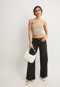 Beež rihmata crop top, laiad mustad teksad, teravatipulised beežid kontsad ja valge käekott. Lisandid hõlmavad vöötlit. Siledad tekstuurid.