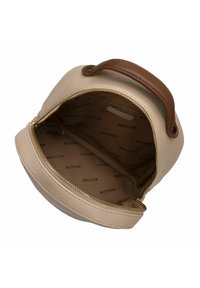 Krémová kožená taška zaobleného tvaru, s hnědou rukojetí a zlatým zipem. Interiér podšitý světlou tkaninou a potištěným názvem značky.