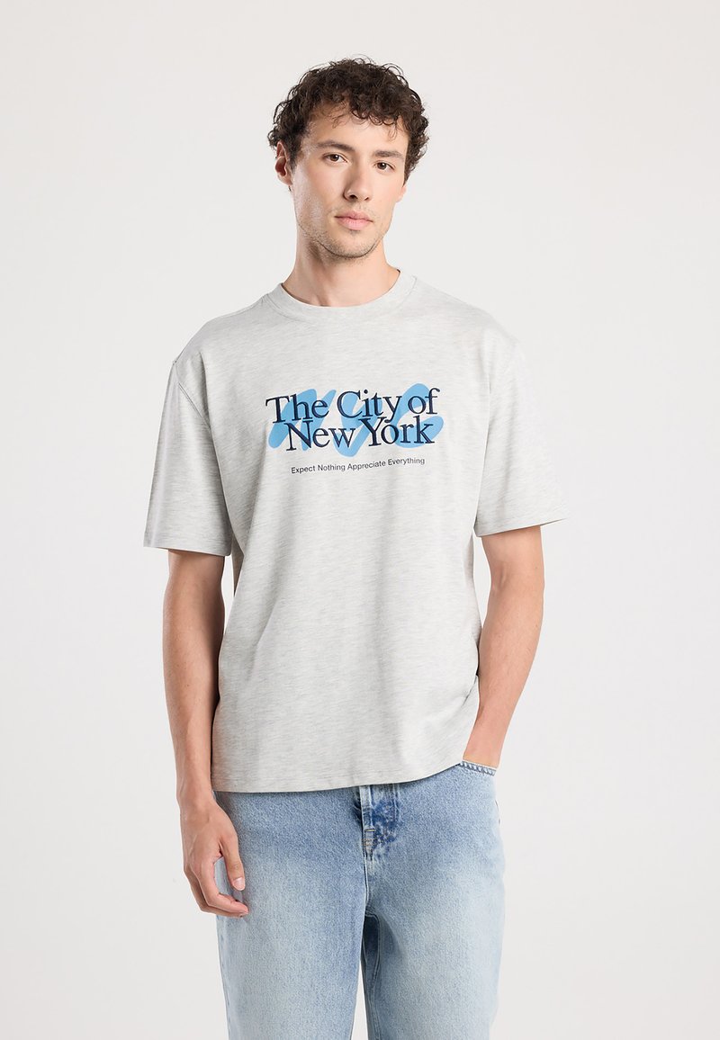Light grey cotton t-shirt featuring a blue graphic that says "The City of New York" with a relaxed fit and short sleeves.