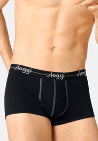 Black trunk underwear with a soft waistband featuring grey "sloggi" logo, detailed with contrasting stitching and a snug fit design.