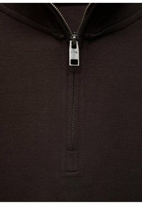 Maglione marrone con zip e colletto alto. Presenta una cerniera argentata e una superficie liscia e testurizzata. Le cuciture sono visibili lungo i bordi.
