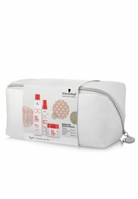 Vit kosmetikväska med en silverdragkedja, med en etikett som visar Schwarzkopf-produkter och cirkulära mönster i rött och beige.