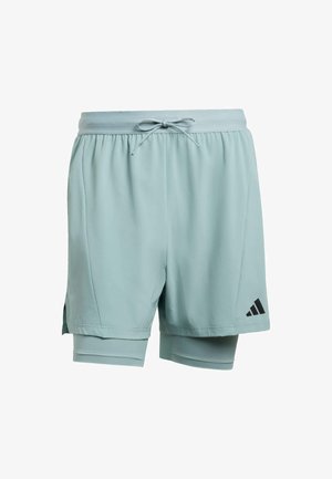 Světlomodré sportovní šortky s vrstvami, vnitřní kompresní podšívkou, šňůrkou v pase a černým logem Adidas na levém lemu.