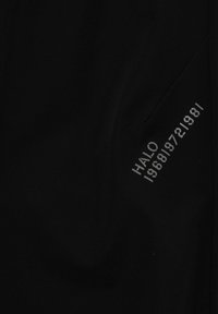 Sort stof med ordet "HALO" og en række tal 198819721981 trykt diagonalt i gråt på højre side.