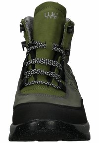 Groene wandelschoenen met een rubberen zool, bovenwerk van gestructureerd leer, zwarte accenten en reflecterende veters. Voorzien van een gevoerde tong voor ondersteuning.
