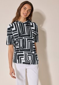 Camiseta con capucha de manga corta, con un patrón geométrico en blanco y negro, hecha de una tela suave, con un corte relajado y cordones.
